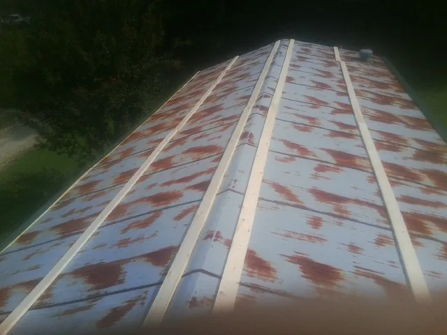 Rusted metal roof panels with new wood purlins before replacement — Storm Damage Roof Repair in Shacklefords by Roofing Brothers