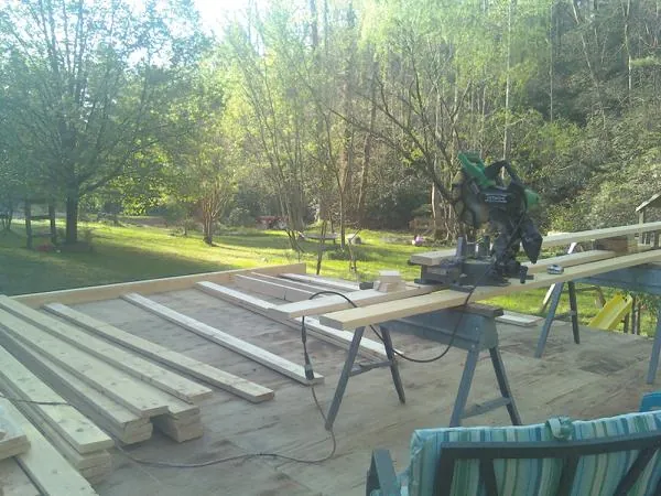 Miter saw and framing lumber on a deck under construction in Shacklefords