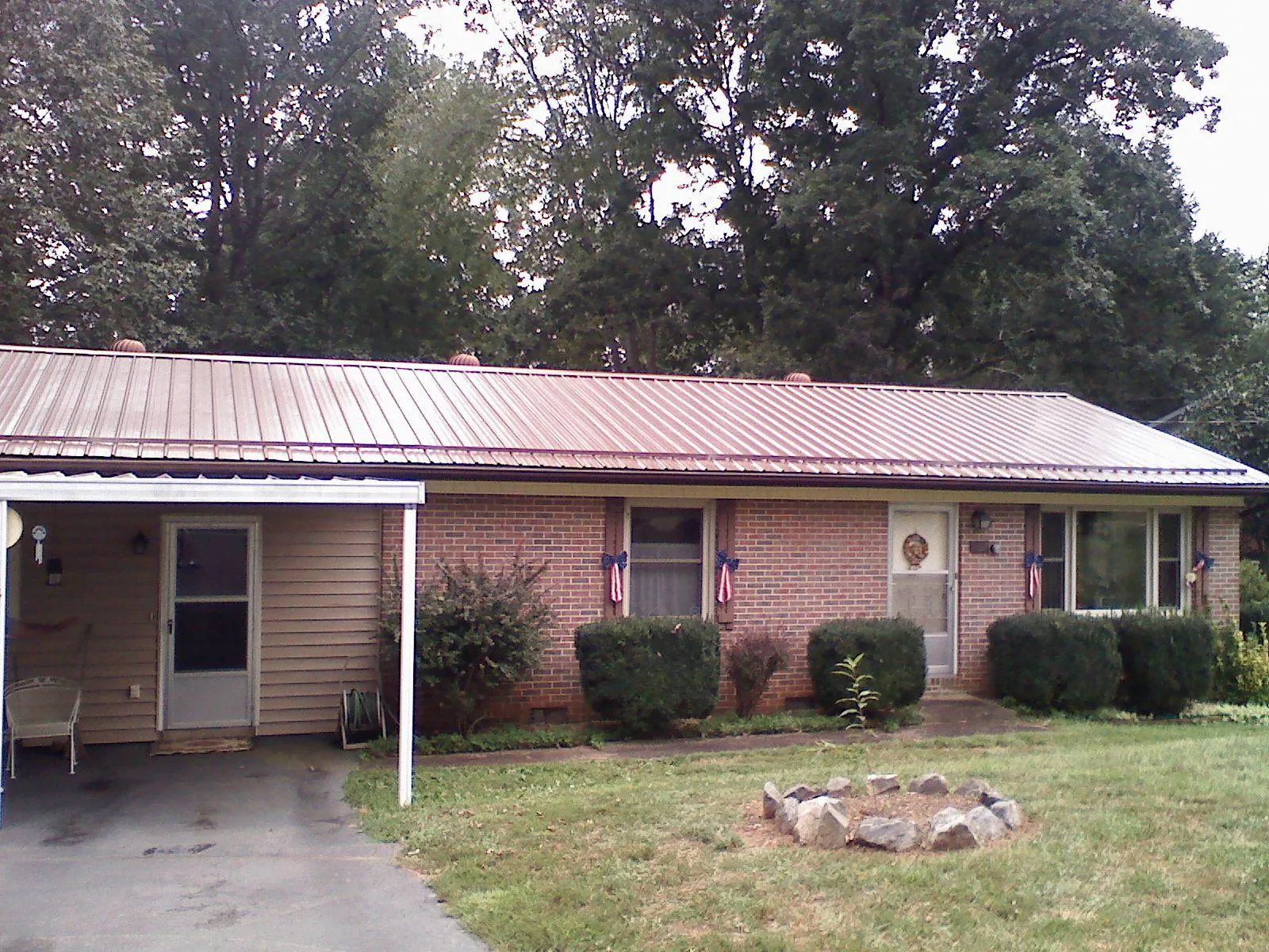 Bronze metal roof and carport on a brick ranch home — Roof Repair work by our crew in Shacklefords