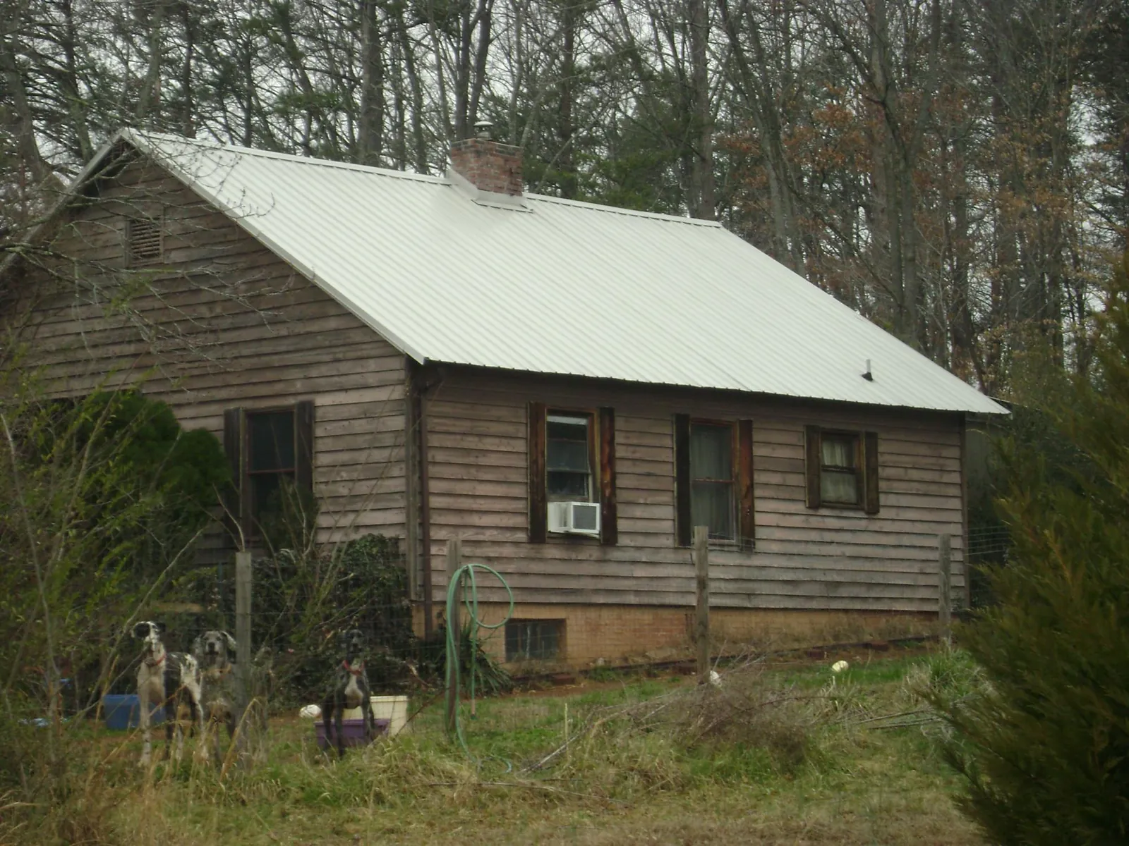 White metal roof on an old wood sided farmhouse, from a Metal Roof Installation job in Shacklefords